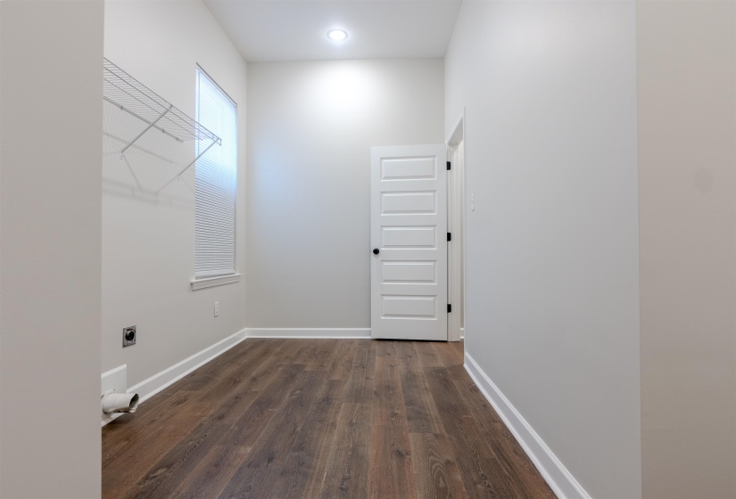 Interior space featuring hookup for an electric dryer and dark wood-type flooring