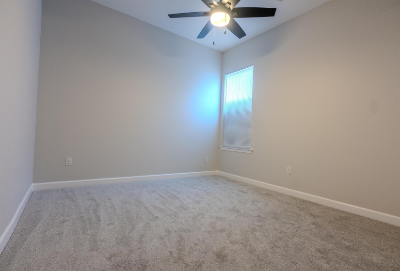 Carpeted spare room with ceiling fan