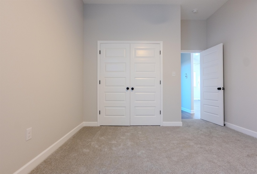 Unfurnished bedroom featuring a closet and light colored carpet
