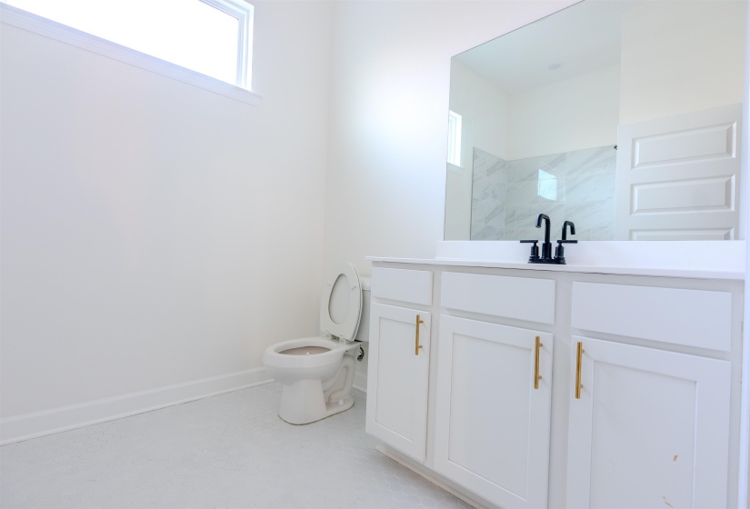 Bathroom featuring a shower, toilet, and vanity