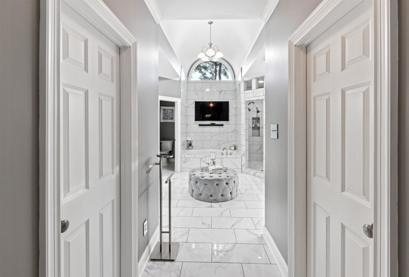 Primary bath featuring lofted ceiling and a chandelier