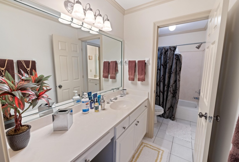 Full bathroom featuring shower / tub combo, vanity, crown molding, toilet, and tile patterned floors