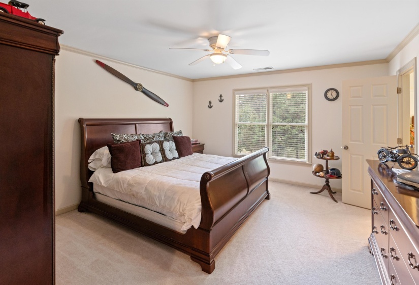 Bedroom featuring ornamental molding, light carpet, and ceiling fan