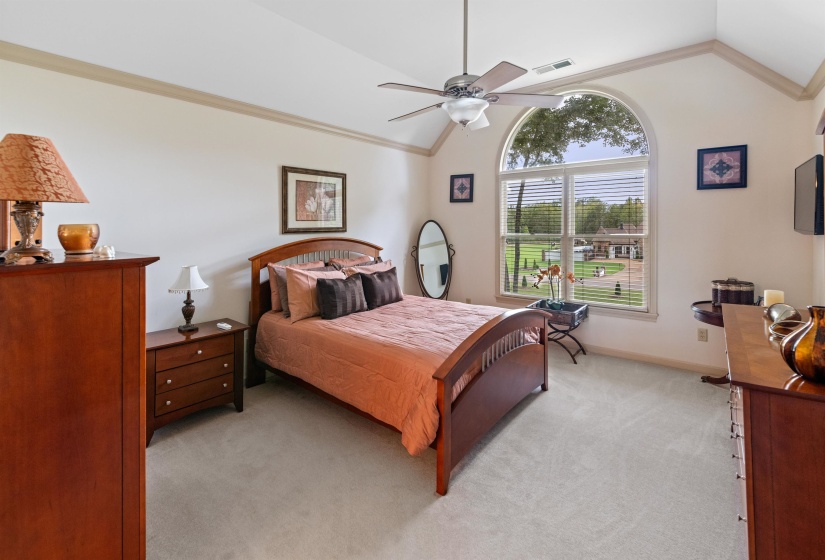 Bedroom featuring light carpet, lofted ceiling, ceiling fan, and ornamental molding