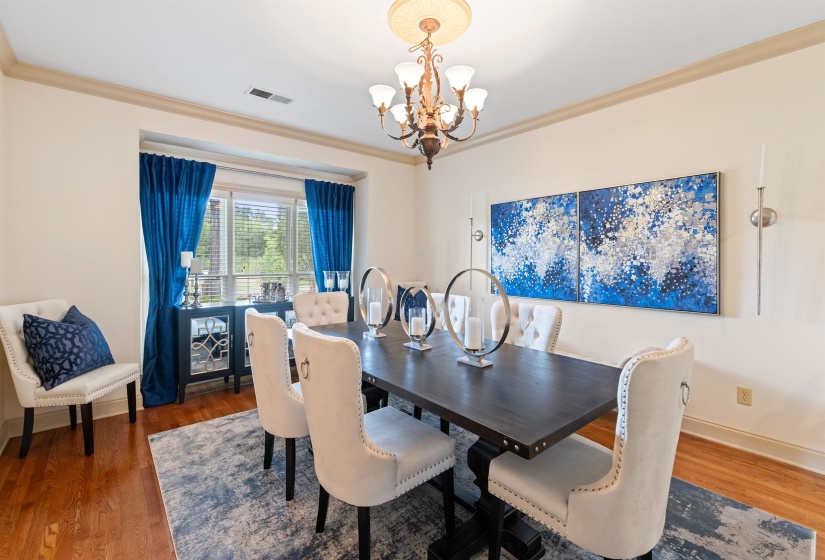 Dining space with a notable chandelier, dark hardwood / wood-style floors, and ornamental molding