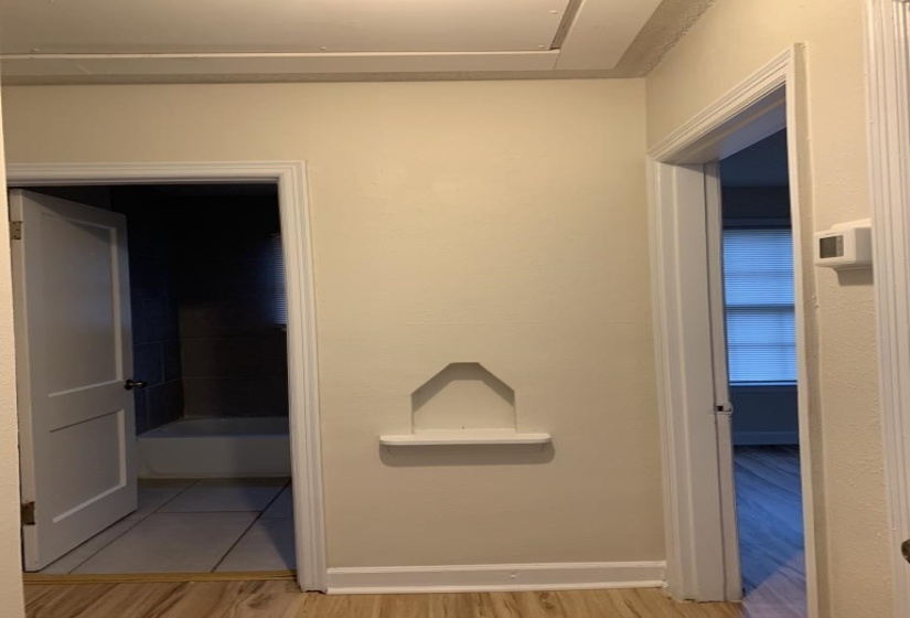 Corridor with hardwood / wood-style floors