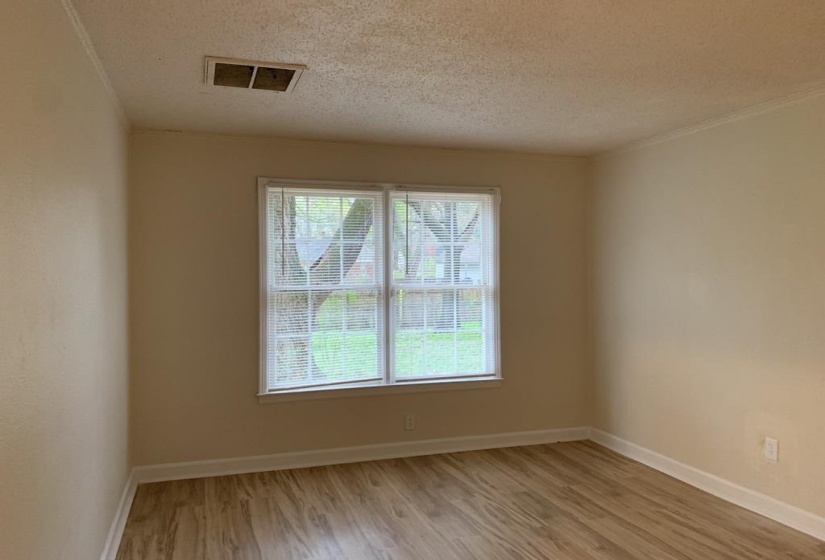 Empty room featuring a textured ceiling and light wood-type flooring