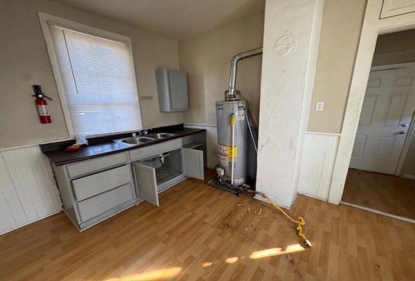 Kitchen featuring light hardwood / wood-style flooring, sink, gas water heater, and gray cabinets