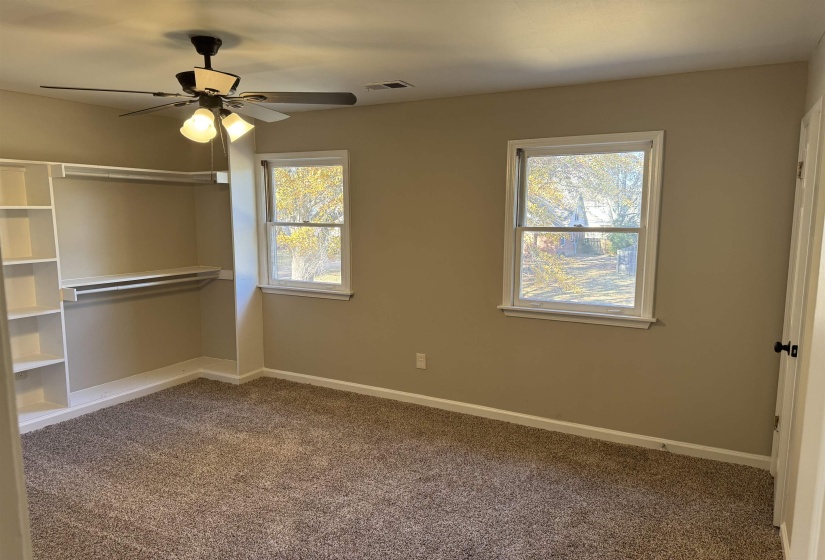 Unfurnished bedroom featuring multiple windows, carpet, and ceiling fan