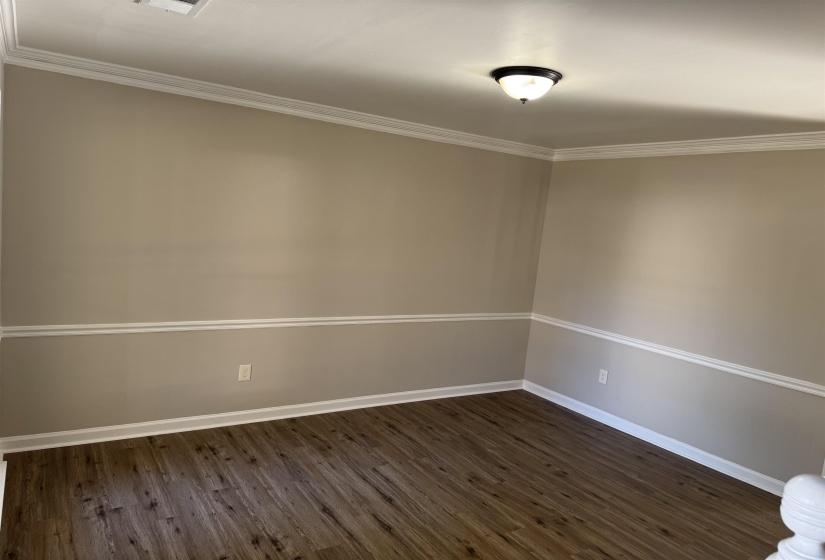 Spare room featuring dark hardwood / wood-style floors and crown molding