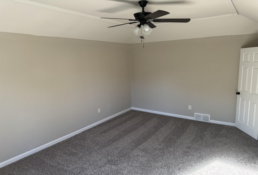 Carpeted spare room with vaulted ceiling and ceiling fan