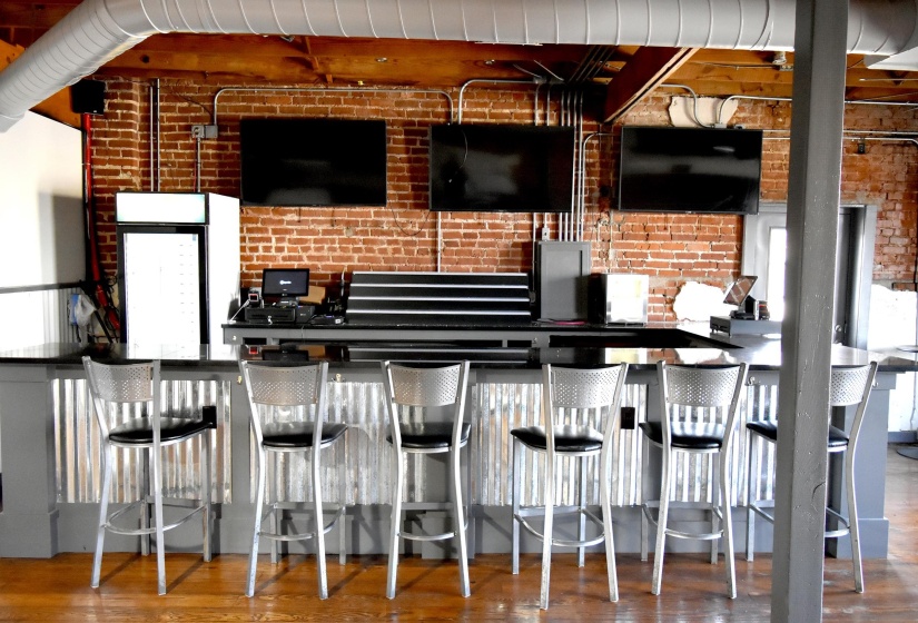 Upstairs Bar featuring brick wall and hardwood / wood-style floors