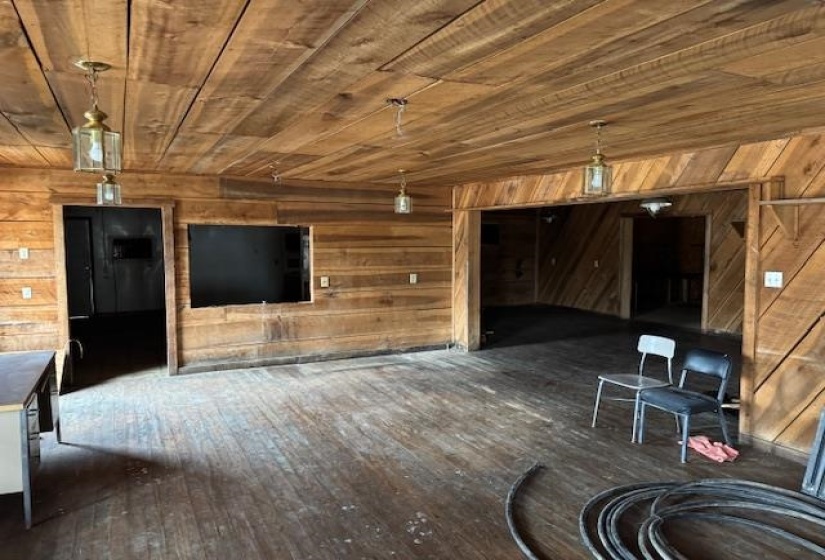 Unfurnished living room with wood ceiling, dark hardwood / wood-style floors, and wooden walls