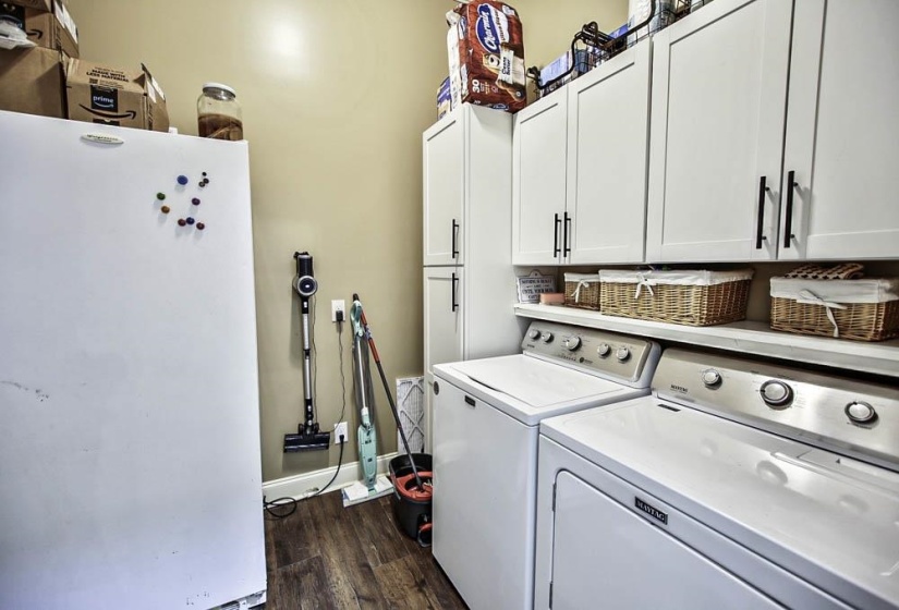 Laundry room with cabinets, dark hardwood / wood-style floors, and washer and clothes dryer