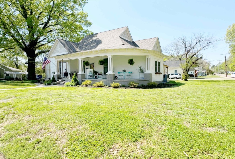 Farmhouse inspired home featuring a porch and a front lawn