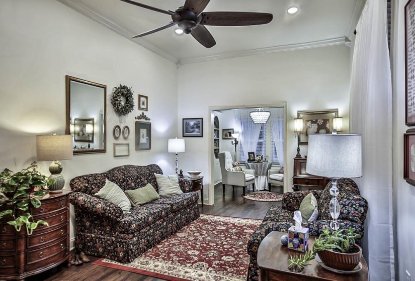 Living room with crown molding, ceiling fan, and hardwood / wood-style flooring