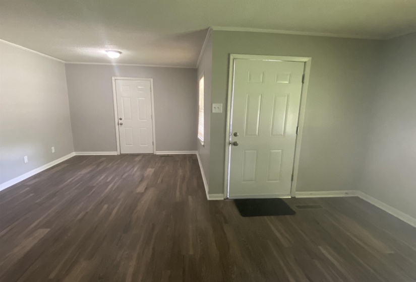 Entrance foyer featuring dark wood-type flooring and ornamental molding