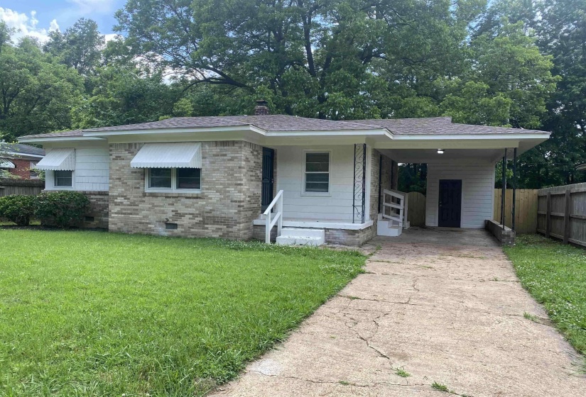 Ranch-style house featuring a carport and a front yard