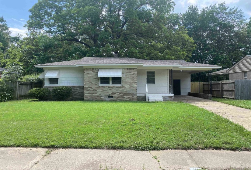 View of front of house featuring a carport and a front yard