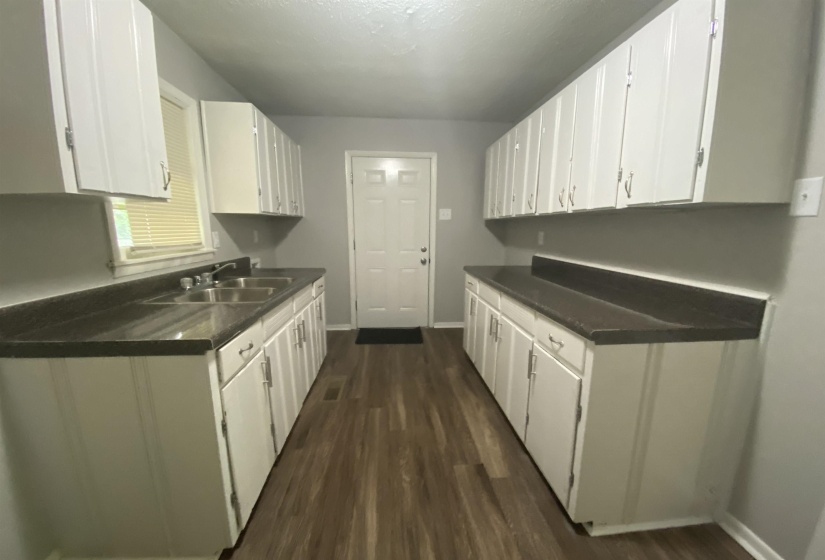 Kitchen featuring sink, dark wood-type flooring, and white cabinets