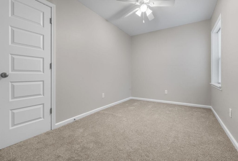 Carpeted empty room featuring ceiling fan