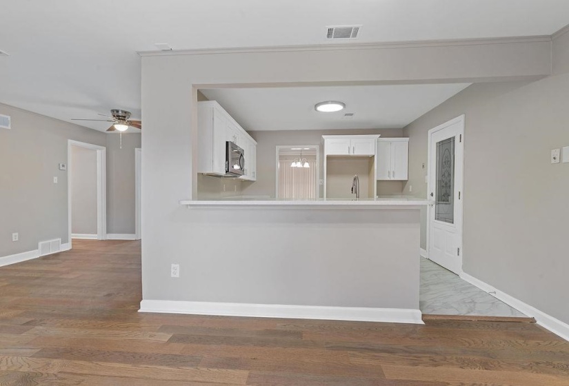 Kitchen featuring tile floors, sink, white cabinets with crown molding, and kitchen peninsula