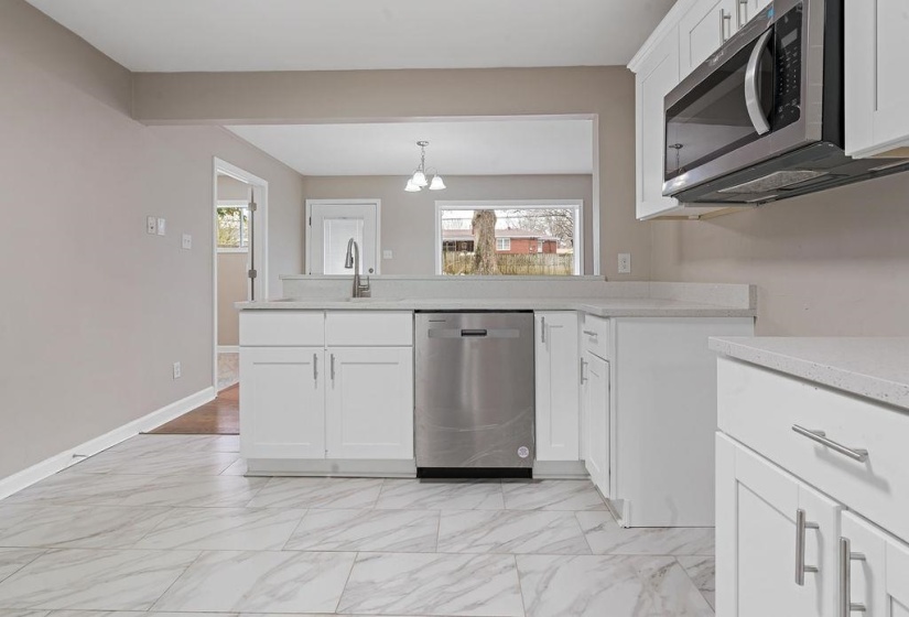 Kitchen featuring stainless steel appliances, white cabinetry, plenty of natural light, and sink