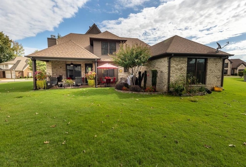 Back of property featuring ceiling fan, a patio area, and a lawn