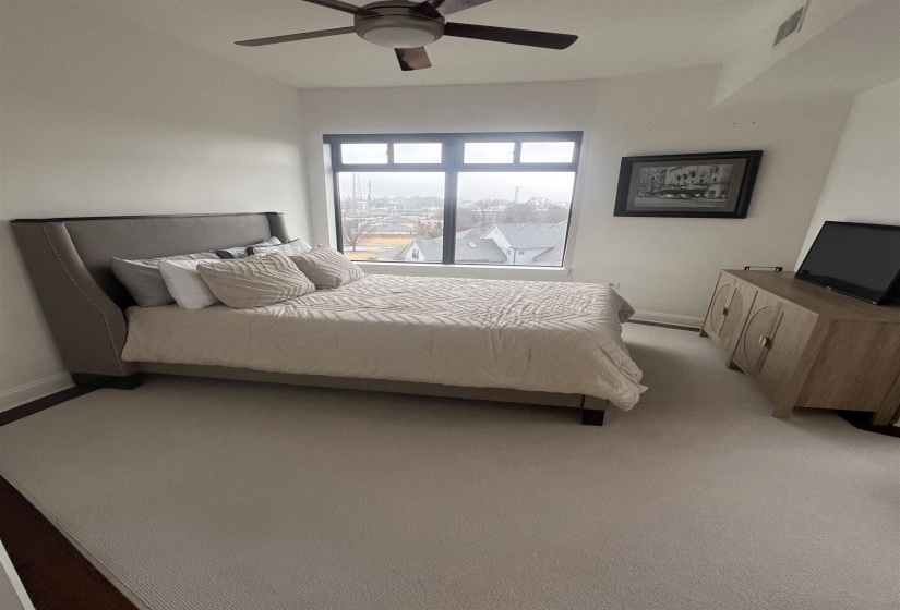 Carpeted bedroom featuring ceiling fan