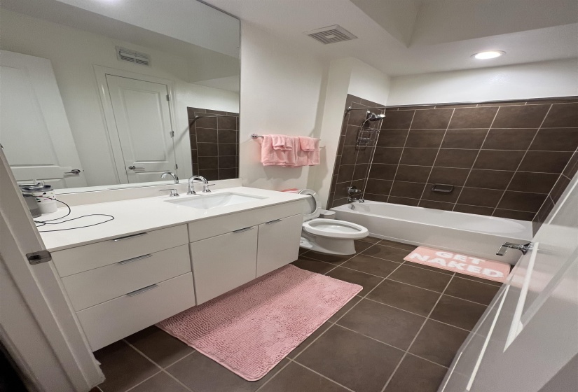 Full bathroom featuring tile patterned flooring, vanity, toilet, and tiled shower / bath
