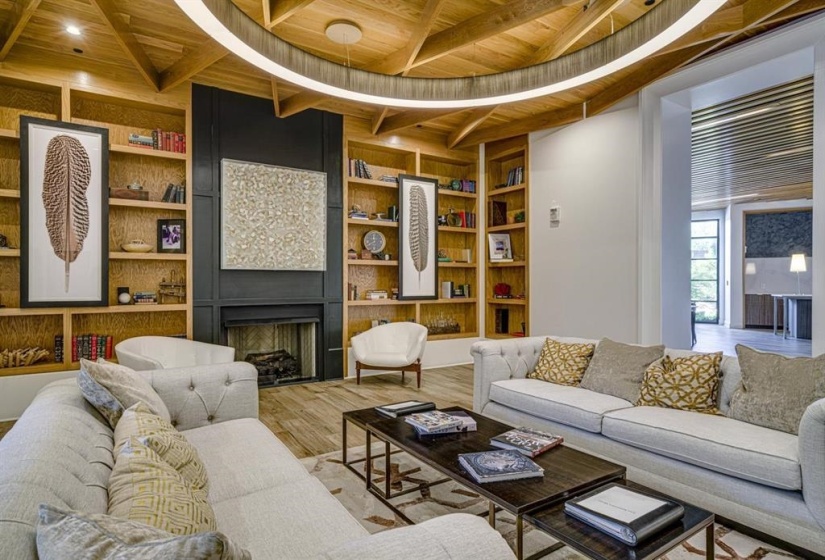 Living room with built in features, a large fireplace, hardwood / wood-style flooring, wood ceiling, and beam ceiling