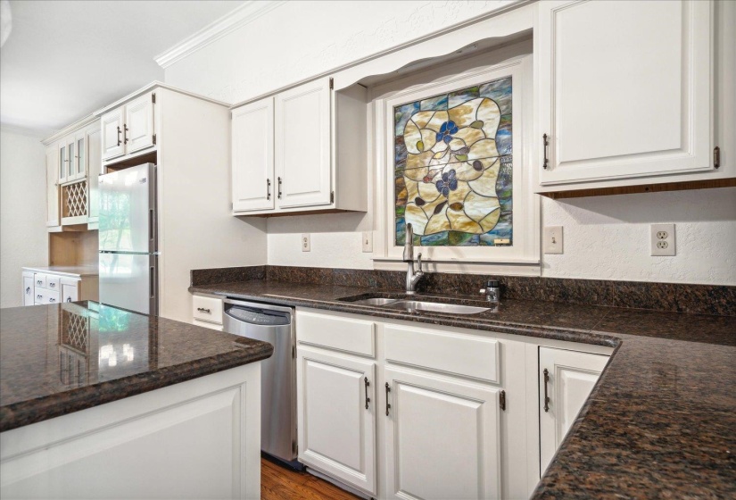 Gorgeous stained glass is featured above the kitchen sink.