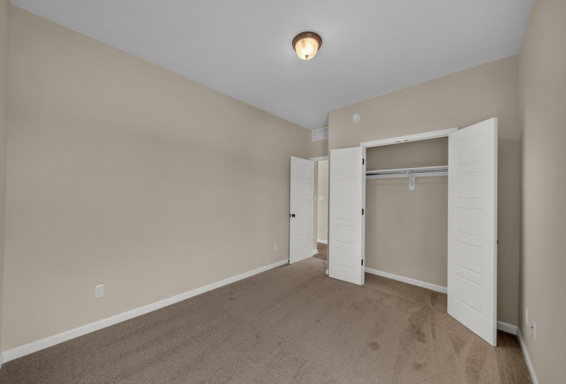 Unfurnished bedroom featuring baseboards, carpet flooring, visible vents, and a closet