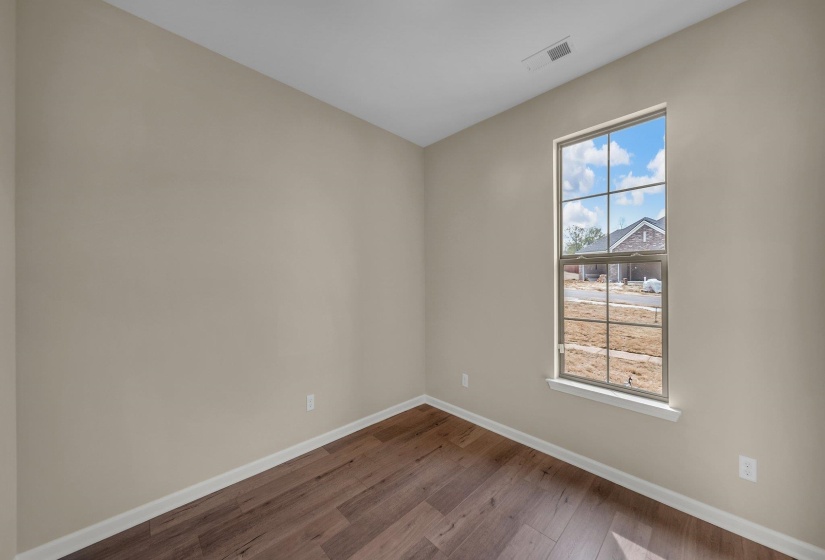 Unfurnished room featuring baseboards, visible vents, and wood finished floors
