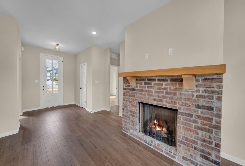 Unfurnished living room with baseboards, a fireplace, and dark wood finished floors