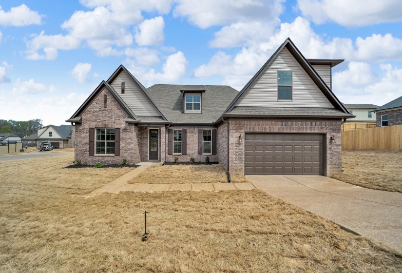 View of front of home with roof with shingles, fence, an attached garage, driveway, and brick siding