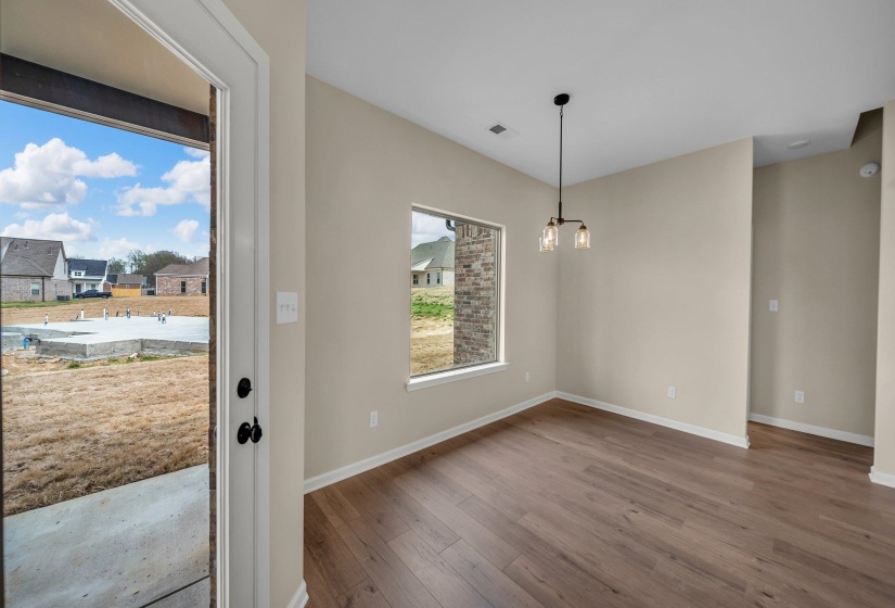 Foyer with baseboards, visible vents, wood finished floors, and an inviting chandelier