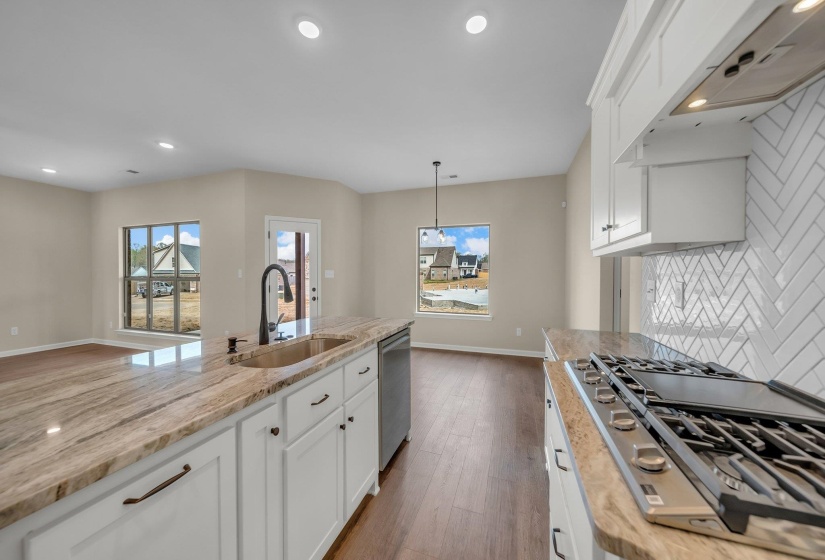 Kitchen featuring backsplash, a sink, white cabinetry, stainless steel appliances, and dark wood-type flooring