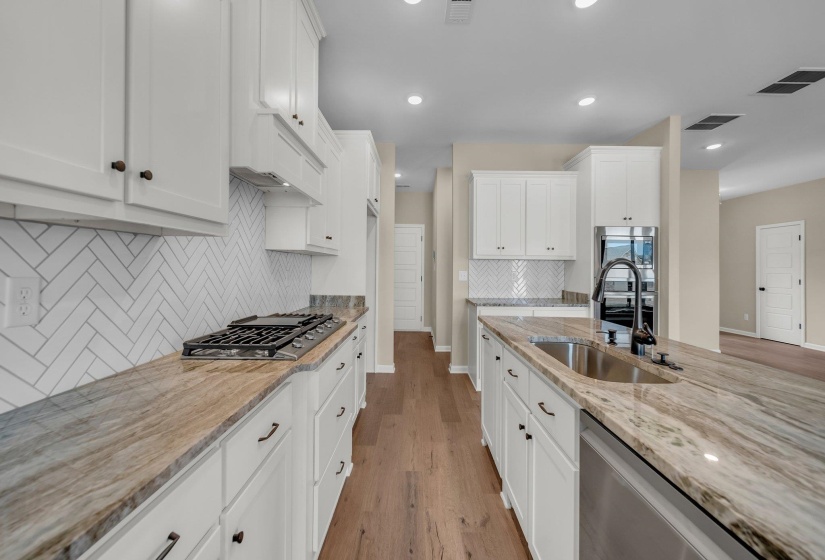 Kitchen with visible vents, light stone counters, light wood-type flooring, and appliances with stainless steel finishes
