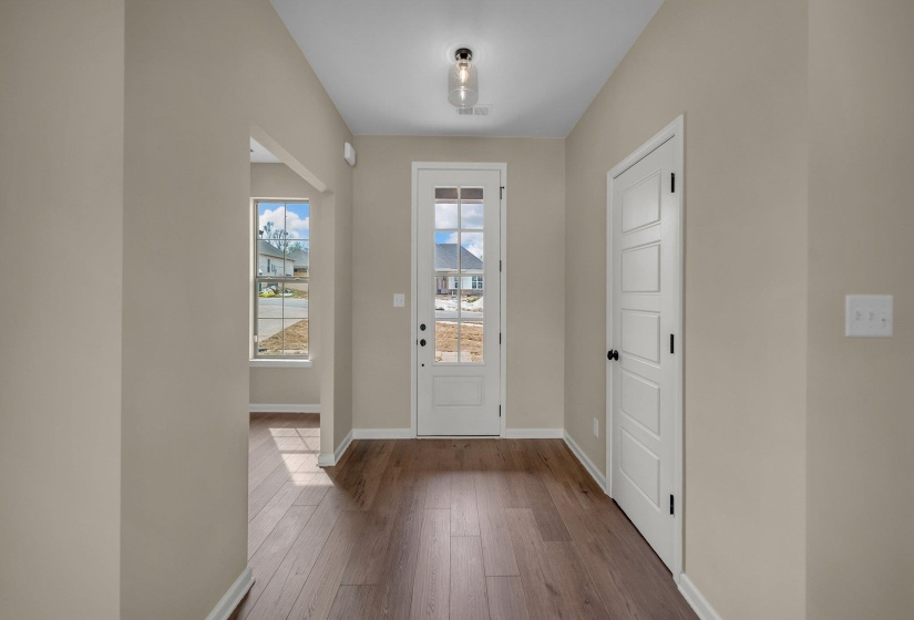 Foyer entrance featuring baseboards, visible vents, and wood finished floors