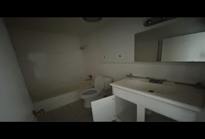 Bathroom featuring toilet, backsplash, tile patterned floors, shower / washtub combination, and a sink