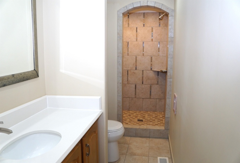 Full bath featuring a stall shower, vanity, toilet, and tile patterned floors