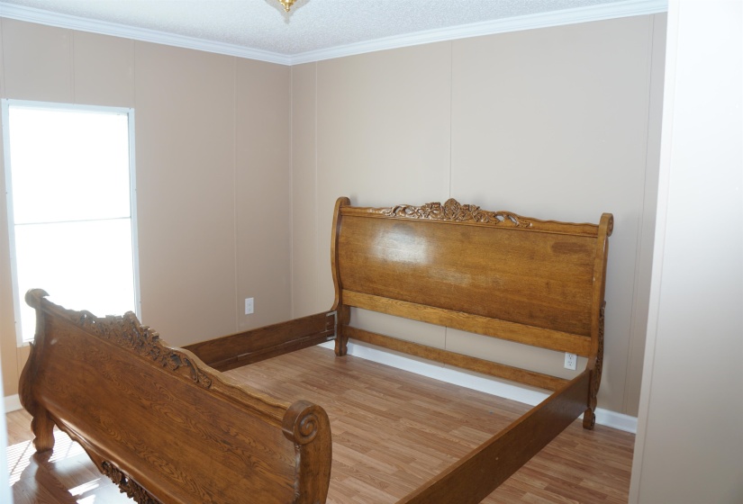 Bedroom featuring crown molding, baseboards, and wood finished floors