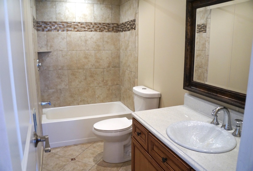 Full bath featuring tile patterned flooring, tub / shower combination, vanity, and toilet