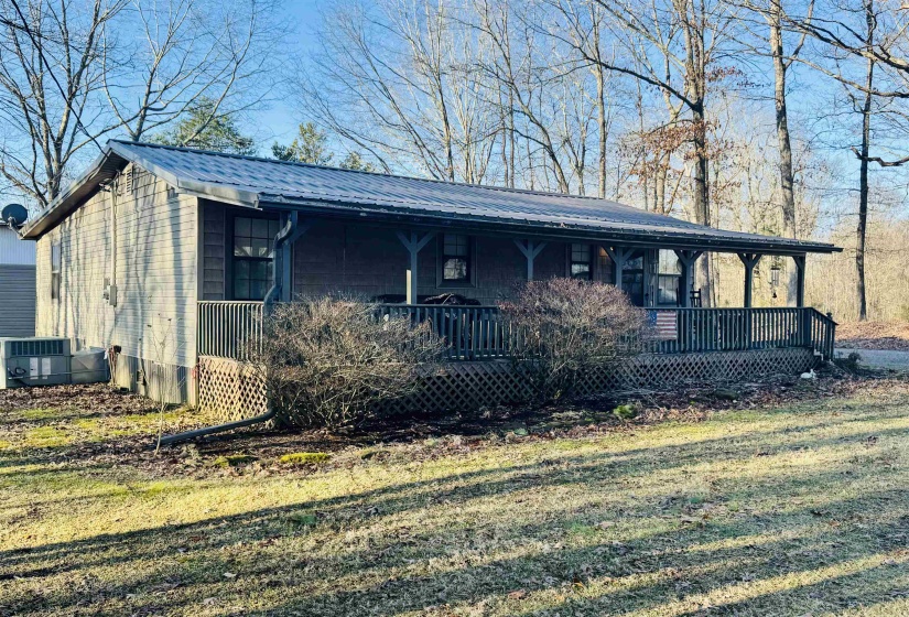 View of front of home featuring metal roof, covered porch, and central AC