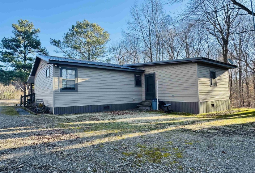 Back of house with entry steps, metal roof, and crawl space