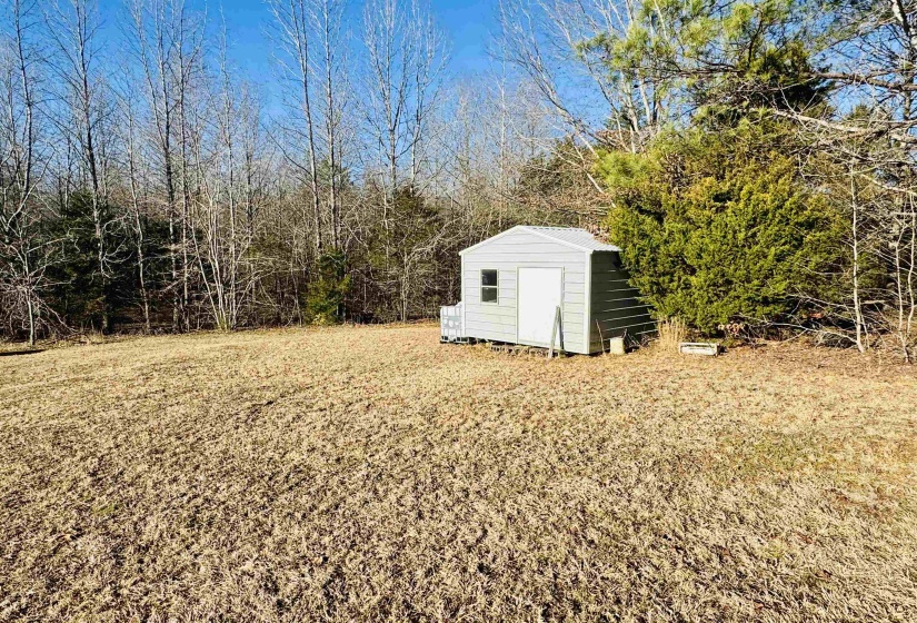 View of yard featuring a storage unit and an outbuilding