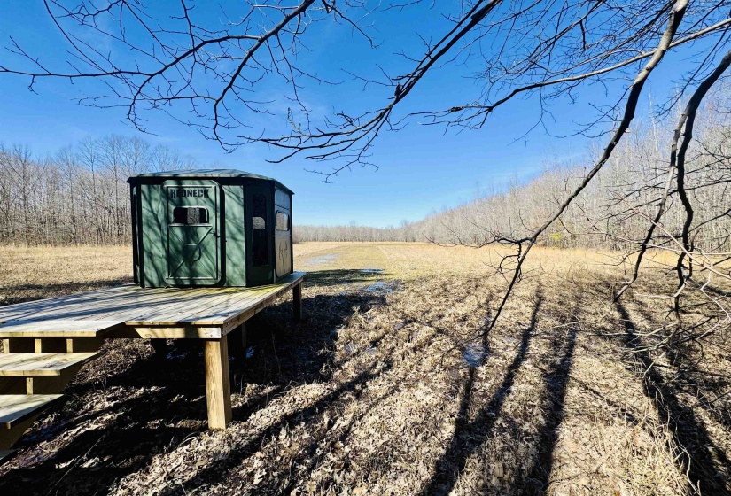 View of property's community featuring a shed, a rural view, and an outdoor structure
