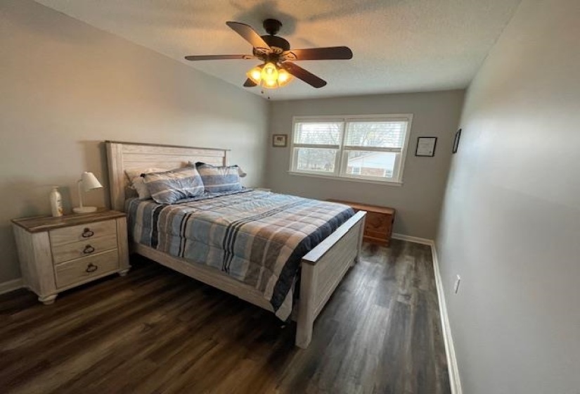 Bedroom with dark wood finished floors, a ceiling fan, baseboards, and a textured ceiling