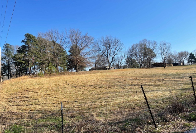 View of yard with a rural view and fence
